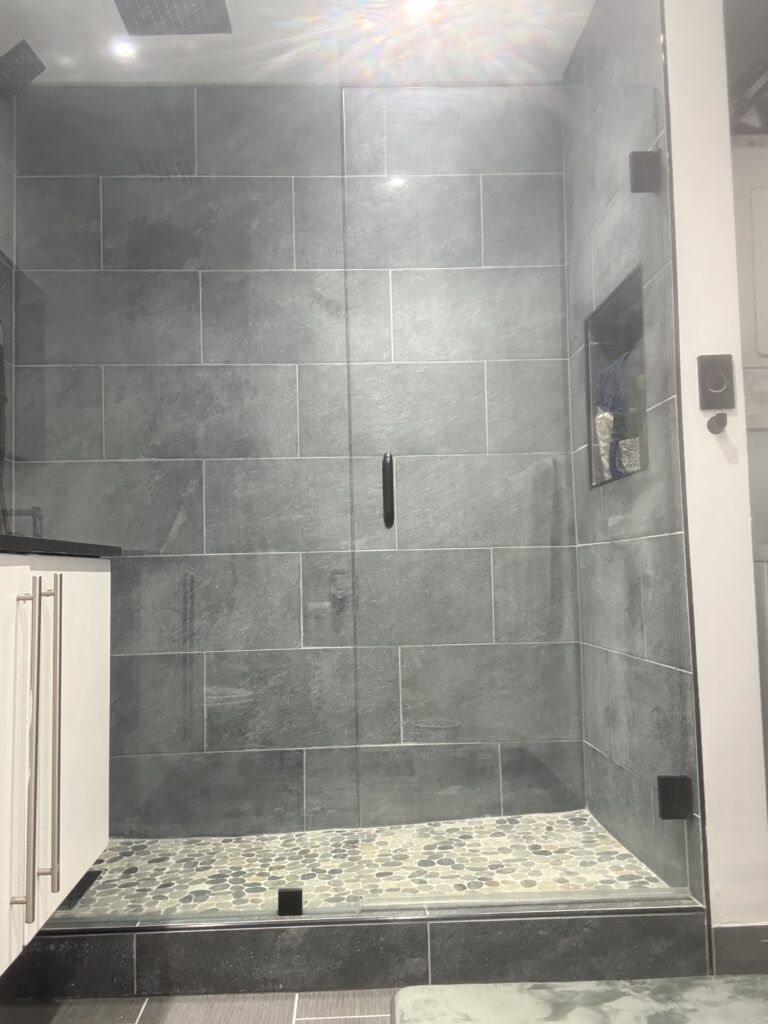 Modern bathroom shower featuring sleek gray tiles